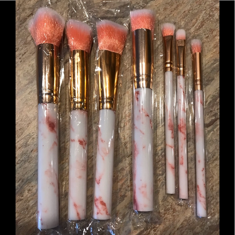 7 make up brushes.  4 large 3 small pink handles